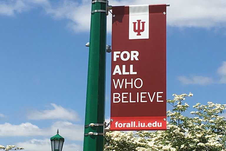 IU For all who believe banner on IU campus